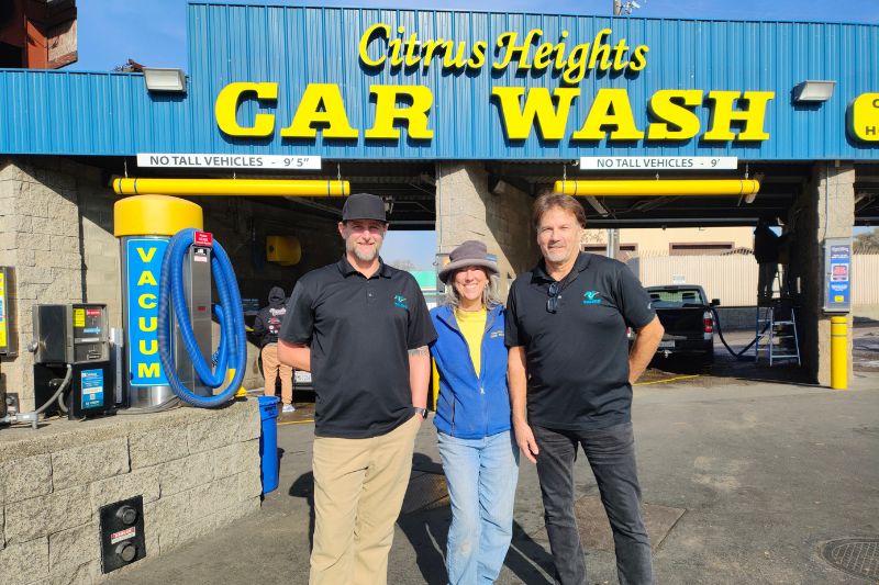 New owner Randy Pastor and son-in-law Scott Woltzen stand with Citrus Heights Car Wash owner Kimberly Berg.