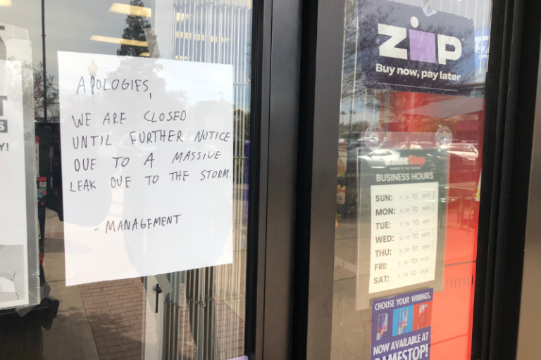 A sign on the window of GameStop indicated the store was closed due to a massive leak following recent storms last week
