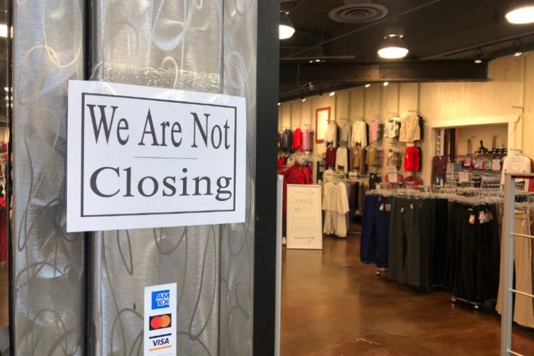 A sign outside of California Basics, located at Sunrise Mall, that reads "We are not closing."