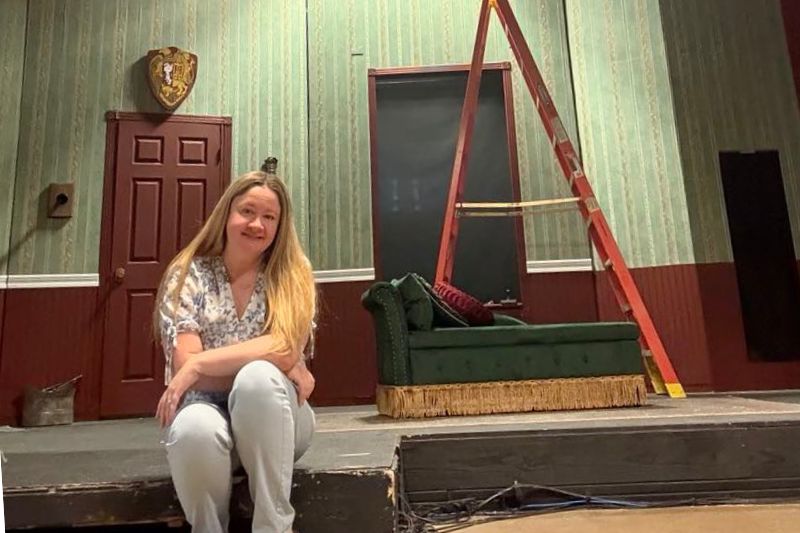 Royal Stage Performing and Visual Arts founder Tammy Warta sits on set inside the Royal Stage theater at Sunrise Mall. April 5, 2025. // Courtesy of Tammy Warta