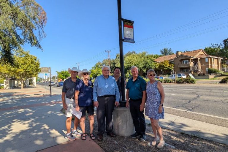 Several members of the Rotary Club of Citrus Heights stand beneath a newly unveiled Historic Lincoln Highway Memorial Placard at San Juan High School, Aug. 15, 2025.