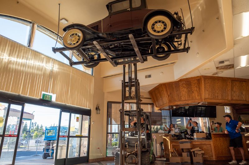Western States Mechanical Owner Jesse Larranaga lifts the 1930 Ford Model A with a forklift as Randy Pastor looks on with family and friends of this gas station.